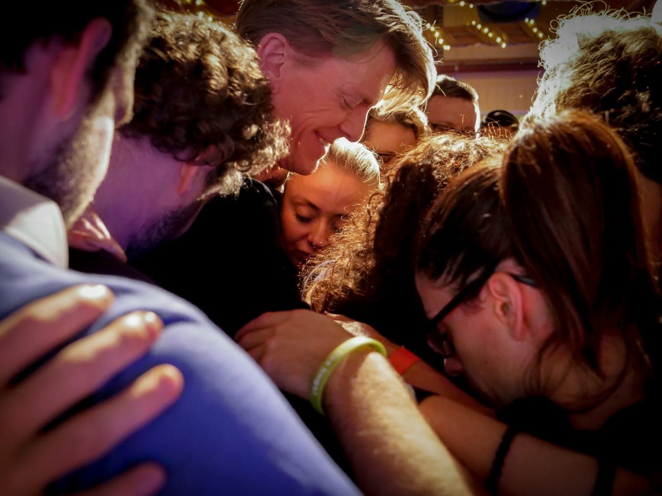 150 people in a group hug at an in-person AWAKEN retreat